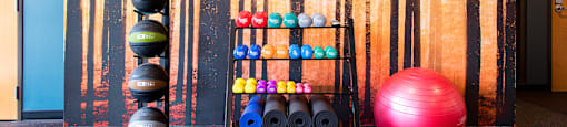 A gym with a sign that says "ENDI" and exercise balls of various colors.