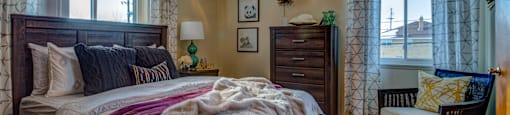 A bedroom with a large bed and a ceiling fan.