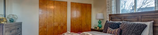 A bedroom with a bed, dresser, and ceiling fan.