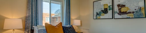 A bedroom with a bed, nightstand, and two framed pictures on the wall.
