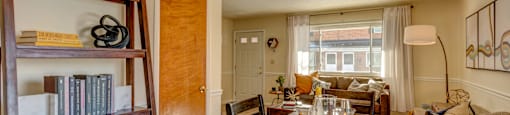 A dining room with a wooden table and chairs.