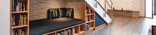 A staircase with a bookshelf on the side.