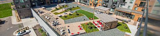 A parking lot with a red car is in front of a building.