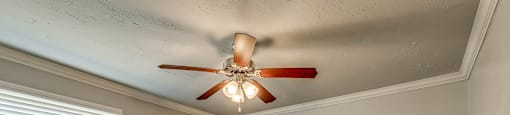 A room with a ceiling fan and carpeted floor.