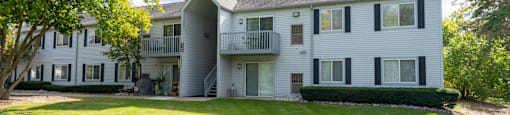 white apartment building with green grass and trees