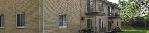 A brick apartment building with a balcony on the second floor.