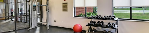 A gym with a red ball and a bench.