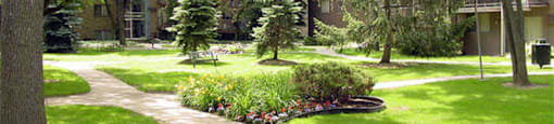 Sidewalk leading to building with landscaping and trees