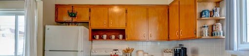 A kitchen with wooden cabinets and a white refrigerator.