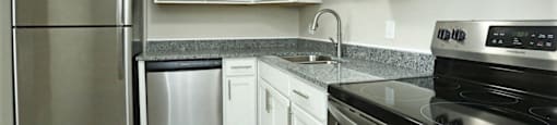 Kitchen with granite counters, stainless appliances, and white cabinets