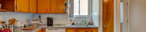 A kitchen with wooden cabinets and a white stove top oven.