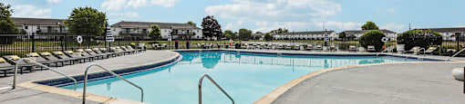 A large outdoor swimming pool with a metal railing.