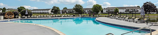 A large outdoor swimming pool with a metal railing around it.