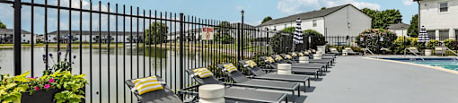 A row of sun loungers are lined up on a patio.