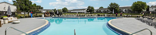 A large outdoor swimming pool with a metal railing around it.