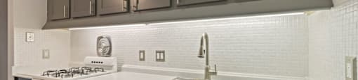 a kitchen with white appliances and gray cabinets
