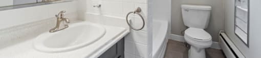a bathroom with a sink toilet and a mirror