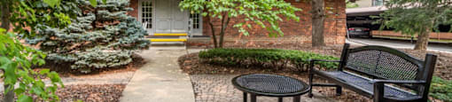 a brick house with a courtyard with a bench and a table