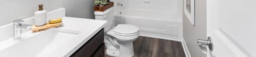 A white bathroom with a toilet, sink, and mirror.
