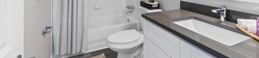 A bathroom with a toilet, sink, and shower.