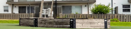 A white building with a balcony and a wooden fence in front.