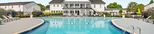 A large swimming pool in front of a white building.