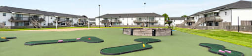 A miniature golf course with green and yellow flags.