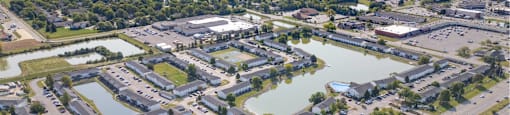A bird's eye view of a residential area with a lake and apartment buildings.