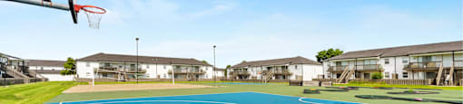A basketball court with a hoop and a blue surface.