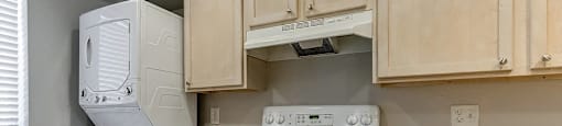A kitchen with white appliances and wooden cabinets.