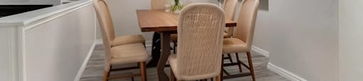 A dining room with a table and chairs.