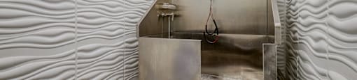 A metal sink in a room with wavy wall panels.