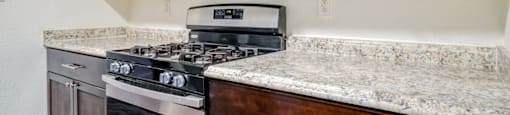 A kitchen with a stove top oven and microwave above it.