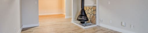 A room with a wood floor and a wood burning stove.