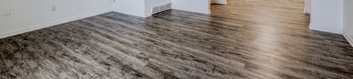 A room with wooden flooring and white walls.