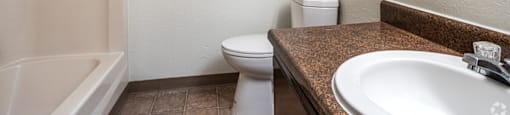 A white toilet sits next to a sink in a bathroom.