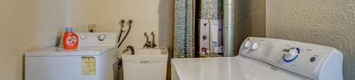A white washing machine and dryer in a small laundry room.
