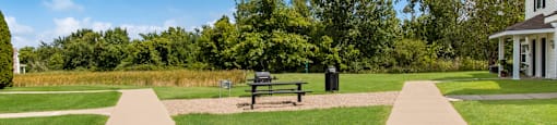 a park with a bench in front of a house