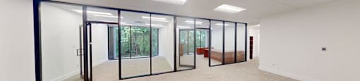 A spacious room with glass doors leading to a balcony.