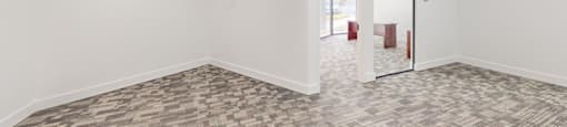 A room with a carpeted floor and a door on the right side.