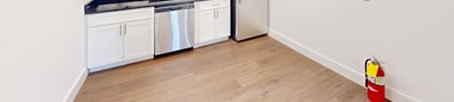 A kitchen with white cabinets and a black countertop.