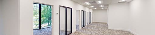 A long hallway with carpeted floors and white walls.