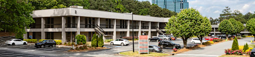 A parking lot with cars and a building in the background.