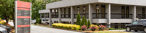 A modern building with a parking lot in front.