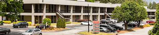 A parking lot with cars and a building in the background.