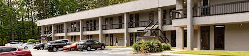 A parking lot with cars and a building in the background.