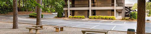 A modern building with a parking lot in front.