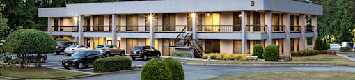 A hotel with a parking lot in front of it.