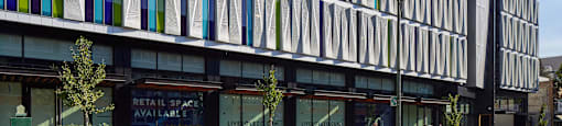 A modern building with a glass facade and a sign that says "Retail Space Available".