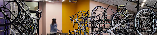 A person walks through a room full of bicycles.